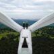 Two Electric engineer wearing Personal protective equipment working on top of wind turbine farm; climate tech investor survey