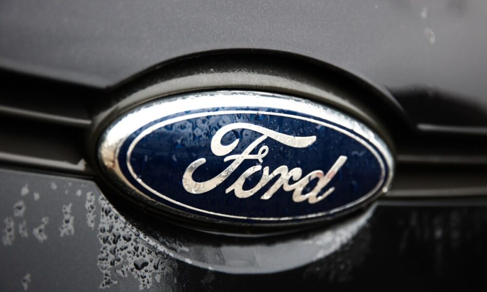 A Ford logo is seen on a gray car.