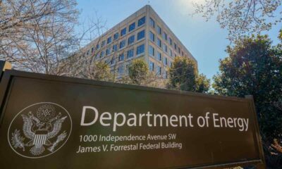 The U.S. Department of Energy building is seen behind a sign marking the location of the agency's headquarters.