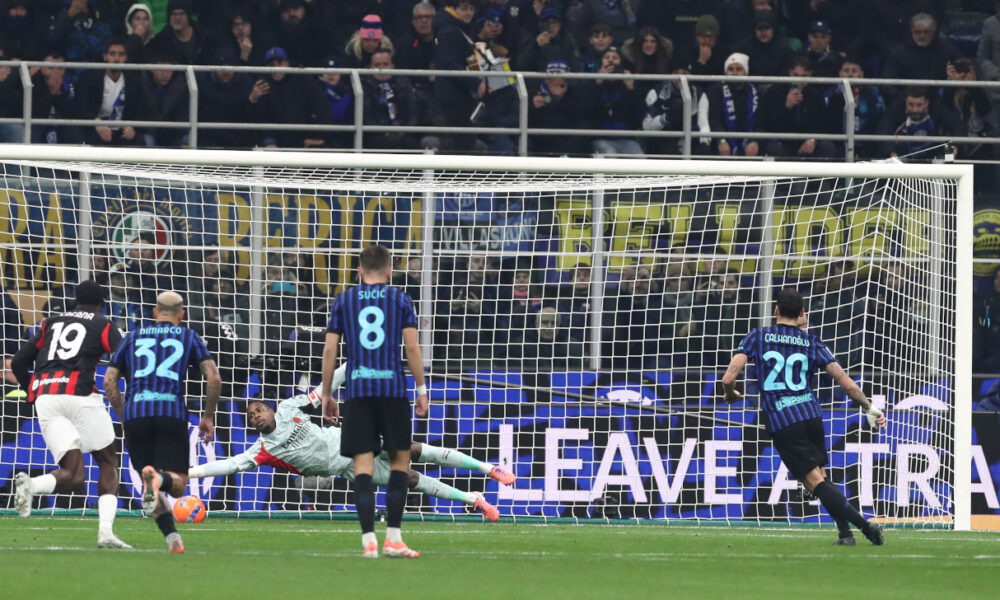 MILAN, ITALY - NOVEMBER 23: Mike Maignan of AC Milan saves a penalty kick Hakan Calhanoglu of FC Internazionale during the Serie A match between FC Internazionale and AC Milan at Giuseppe Meazza Stadium on November 23, 2025 in Milan, Italy. (Photo by Marco Luzzani/Getty Images)