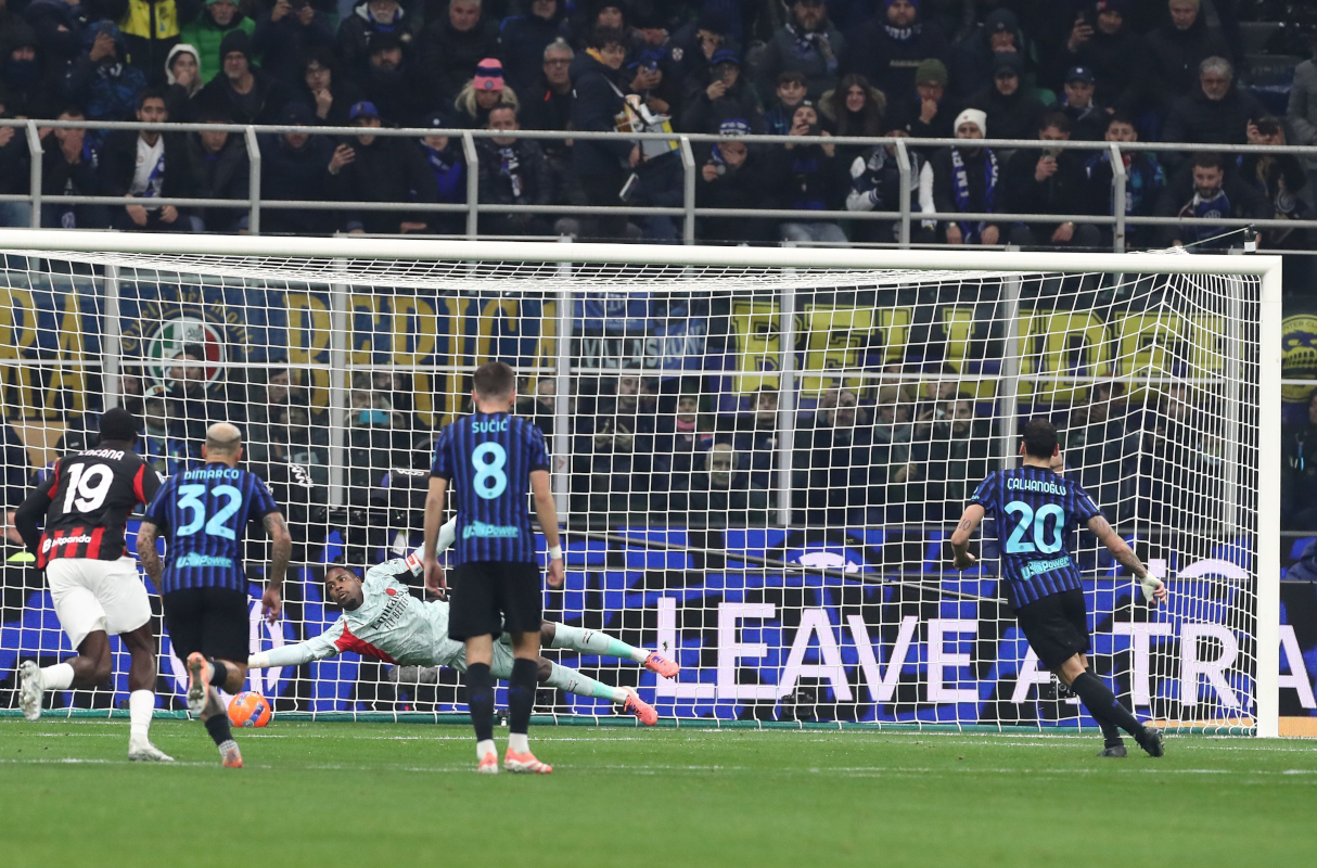 MILAN, ITALY - NOVEMBER 23: Mike Maignan of AC Milan saves a penalty kick Hakan Calhanoglu of FC Internazionale during the Serie A match between FC Internazionale and AC Milan at Giuseppe Meazza Stadium on November 23, 2025 in Milan, Italy. (Photo by Marco Luzzani/Getty Images)
