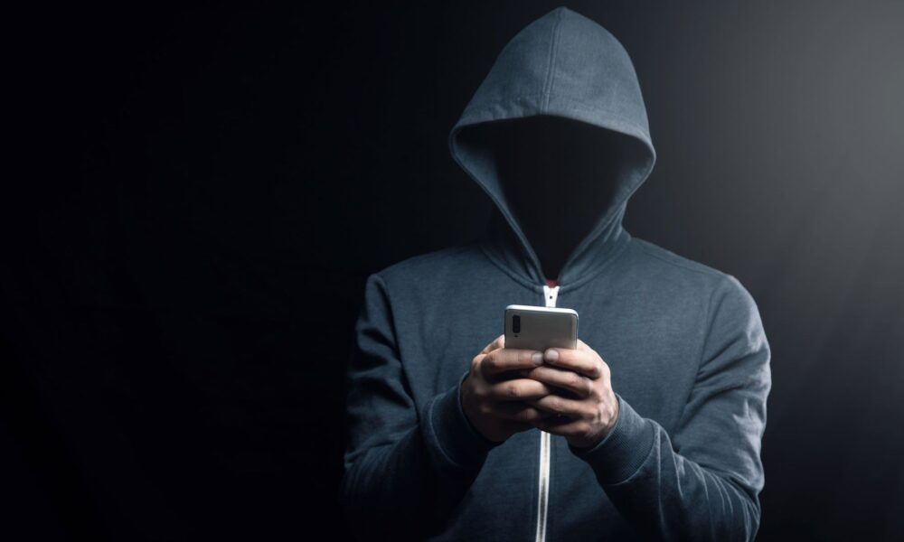 A dark figure in a hoodie representing a hacker.