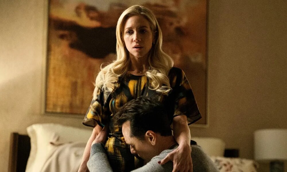 A still from an episode of The Beast in Me, featuring characters played by Snow and Rhys.