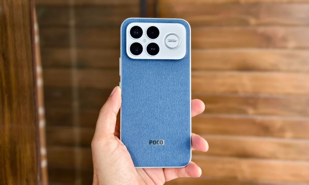 Hand holding the Poco F8 Ultra with denim back and 4 cameras.