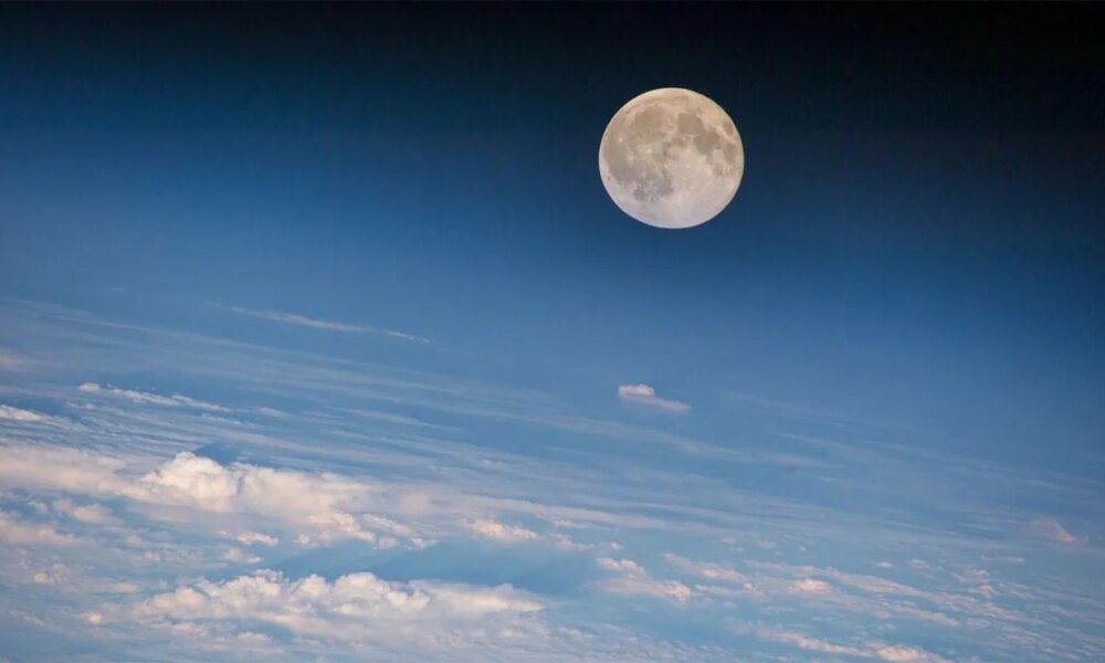 A full moon in the sky with clouds
