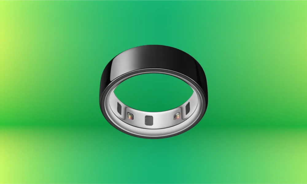 Black Oura Ring on display against green gradient background.