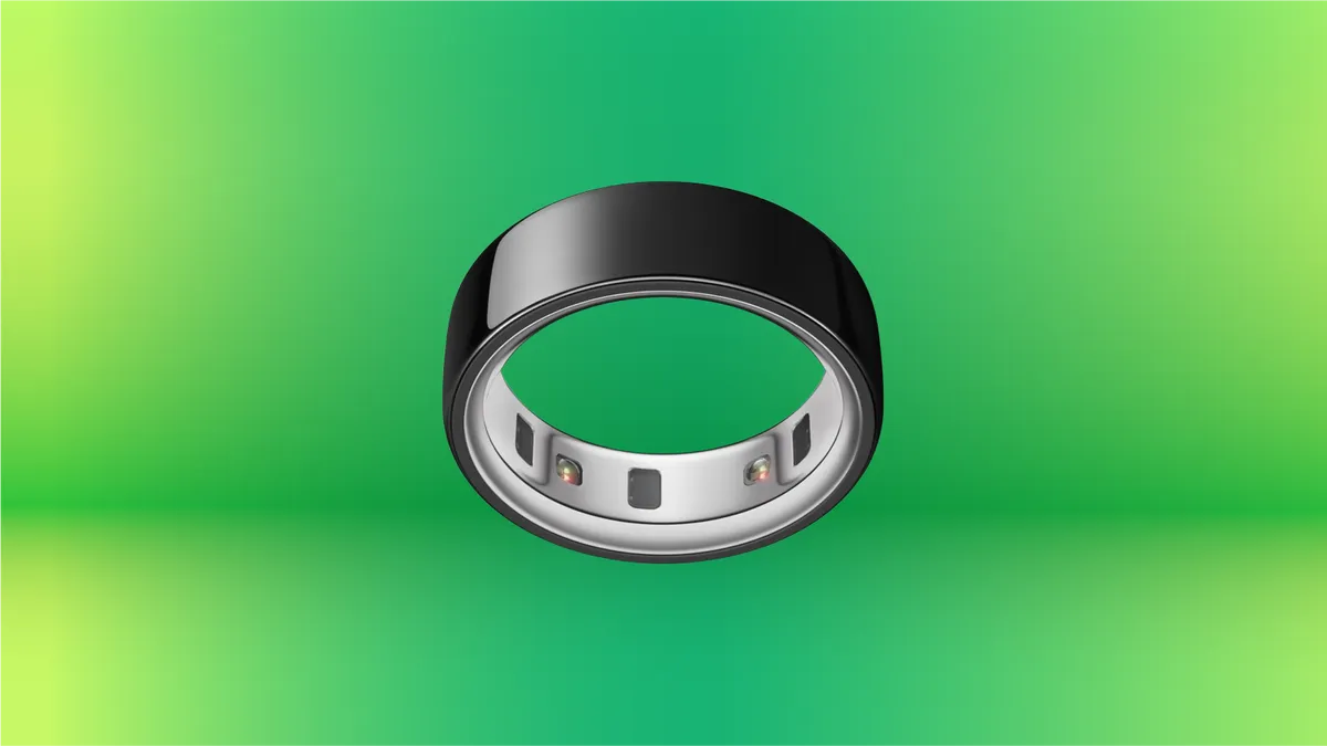 Black Oura Ring on display against green gradient background.