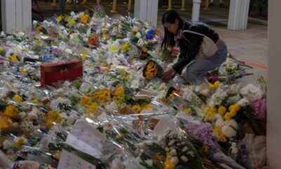 A woman lays flowers near the site of the fire. Pic: AP