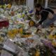 A woman lays flowers near the site of the fire. Pic: AP