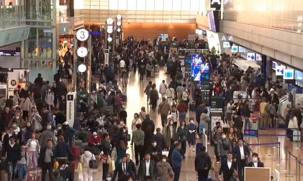 Passengers wait at Haneda Airport in Tokyo after delays from an Airbus software glitch. Pic: AP / NTV