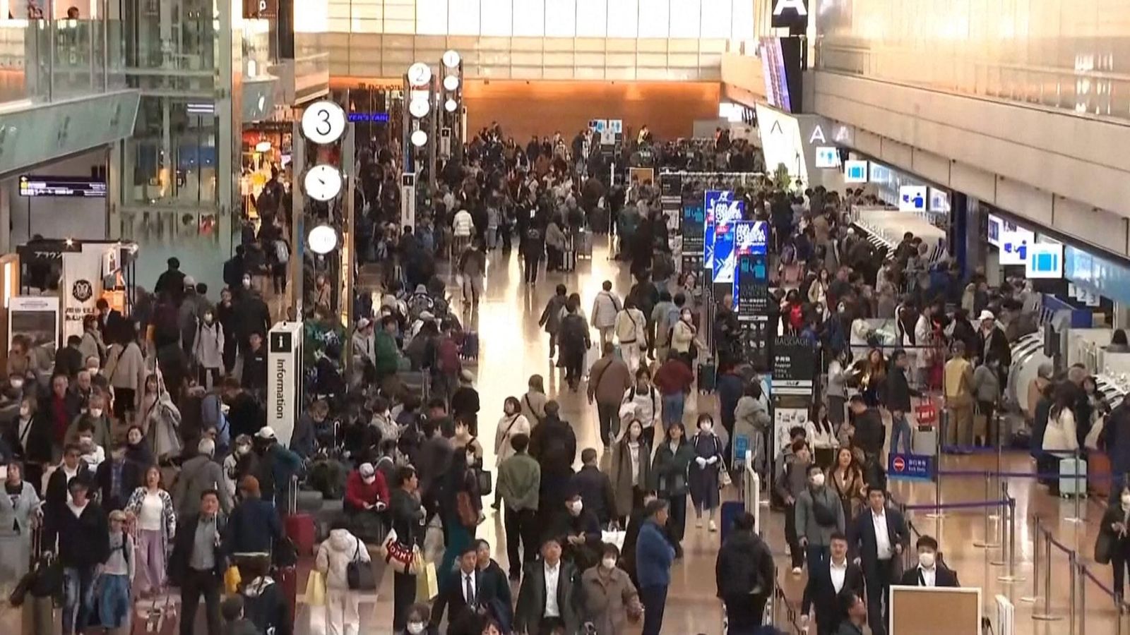 Passengers wait at Haneda Airport in Tokyo after delays from an Airbus software glitch. Pic: AP / NTV