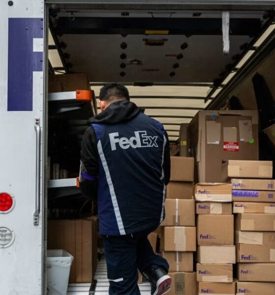 A worker unloading packages from a FedEx truck.