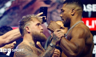 Jake Paul grabs Anthony Joshua's fist during a face-off