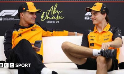 Lando Norris and Oscar Piastri look at each other during the news conference in Abu Dhabi