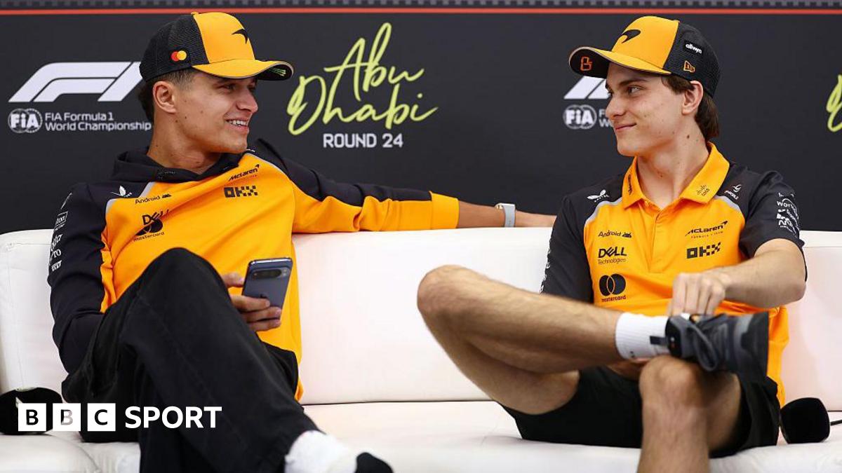Lando Norris and Oscar Piastri look at each other during the news conference in Abu Dhabi