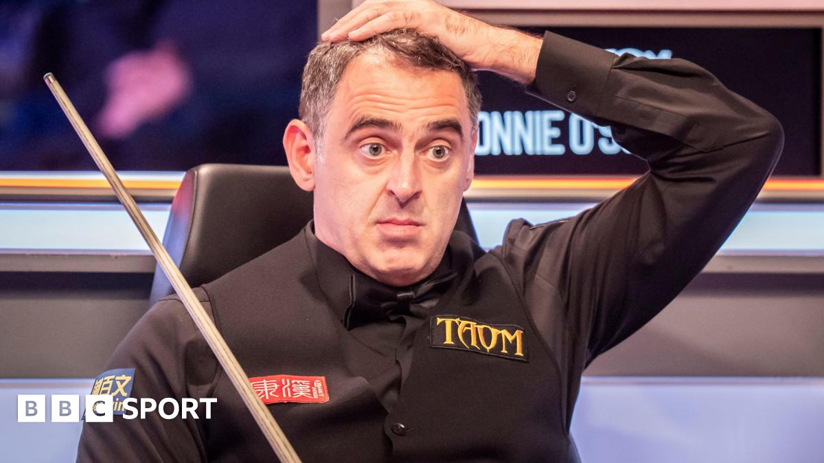 Ronnie O'Sullivan puts his left hand on his head as he watches play from his seat
