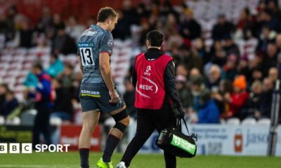 Max Llewellyn (left) walks off the pitch with a medic beside him