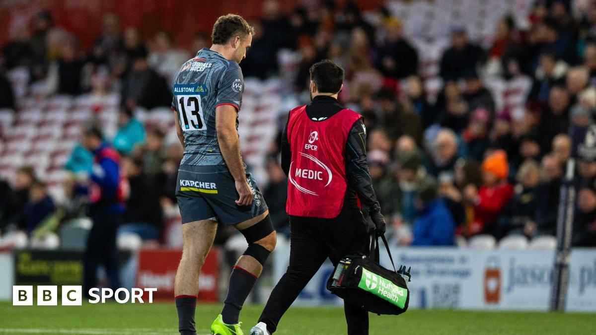 Max Llewellyn (left) walks off the pitch with a medic beside him