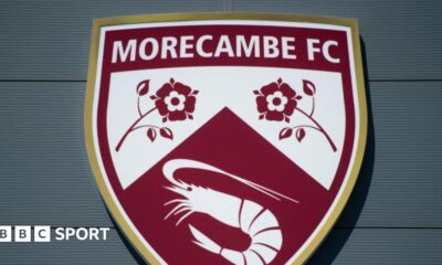 A shot of Morecambe's badge on the exterior of their Mazuma Mobile Stadium