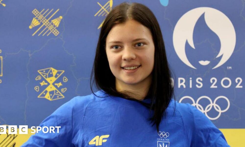 Ukrainian diver Sofiia Lyskun holds a national flag during the welcome ceremony at the Central Railway Terminal upon her return from the Paris 2024 Olympics