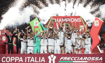 ROME, ITALY - MAY 14: Lewis Ferguson, Lorenzo De Silvestri and Riccardo Orsolini of Bologna lift the Coppa Italia trophy as their team mates celebrate after the team
