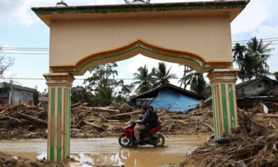 Indonesians climb over logs in walk to aid centre as flood deaths rise over 900