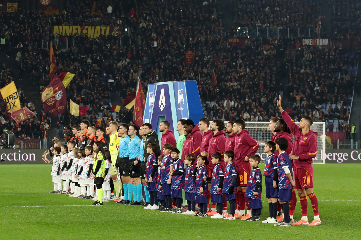 ROME, ITALY - DECEMBER 15: Como 1907 and AS Roma players line up on the pitch prior to the Serie A match between AS Roma and Como 1907 at Stadio Olimpico on December 15, 2025 in Rome, Italy. (Photo by Paolo Bruno/Getty Images)