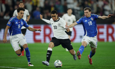 DORTMUND, GERMANY - MARCH 23: Jamal Musiala of Germany is challenged by Nicolo Barella (R) and Samuele Ricci of Italy during the UEFA Nations League Quarterfinal Leg Two match between Germany and Italy at Football Stadium Dortmund on March 23, 2025 in Dortmund, Germany. (Photo by Alex Grimm/Getty Images)
