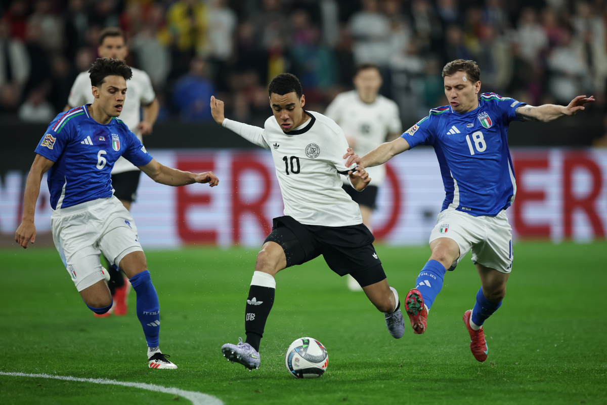 DORTMUND, GERMANY - MARCH 23: Jamal Musiala of Germany is challenged by Nicolo Barella (R) and Samuele Ricci of Italy during the UEFA Nations League Quarterfinal Leg Two match between Germany and Italy at Football Stadium Dortmund on March 23, 2025 in Dortmund, Germany. (Photo by Alex Grimm/Getty Images)