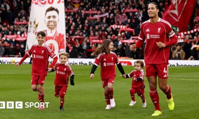 Virgil van Dijk of Liverpool enters the pitch with the children of former player Diogo Jota prior to the Premier League match between Liverpool and Wolves