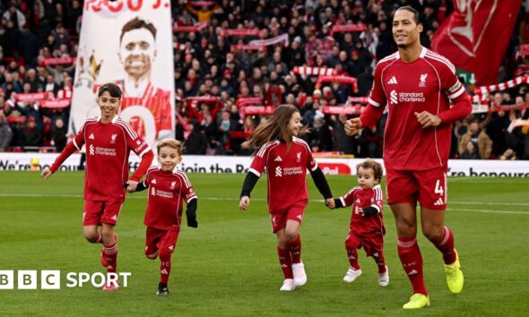 Virgil van Dijk of Liverpool enters the pitch with the children of former player Diogo Jota prior to the Premier League match between Liverpool and Wolves