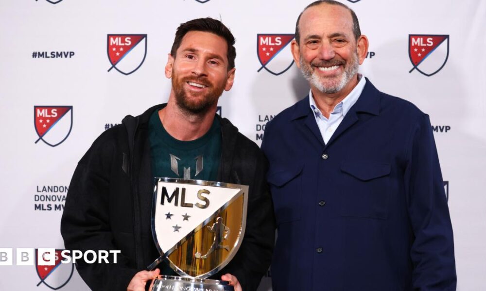 Lionel Messi holding his MLS Most Valuable Player award alongside MLS Commissioner Don Garber.