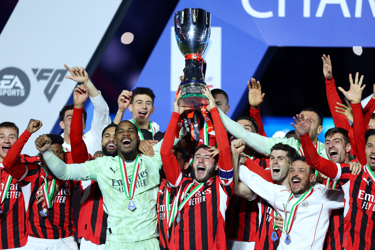 Davide Calabria lifts the Italian Super Cup Trophy after his team