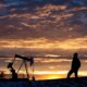 Oilfield Worker or Geologist at Sunrise by Pumpjack