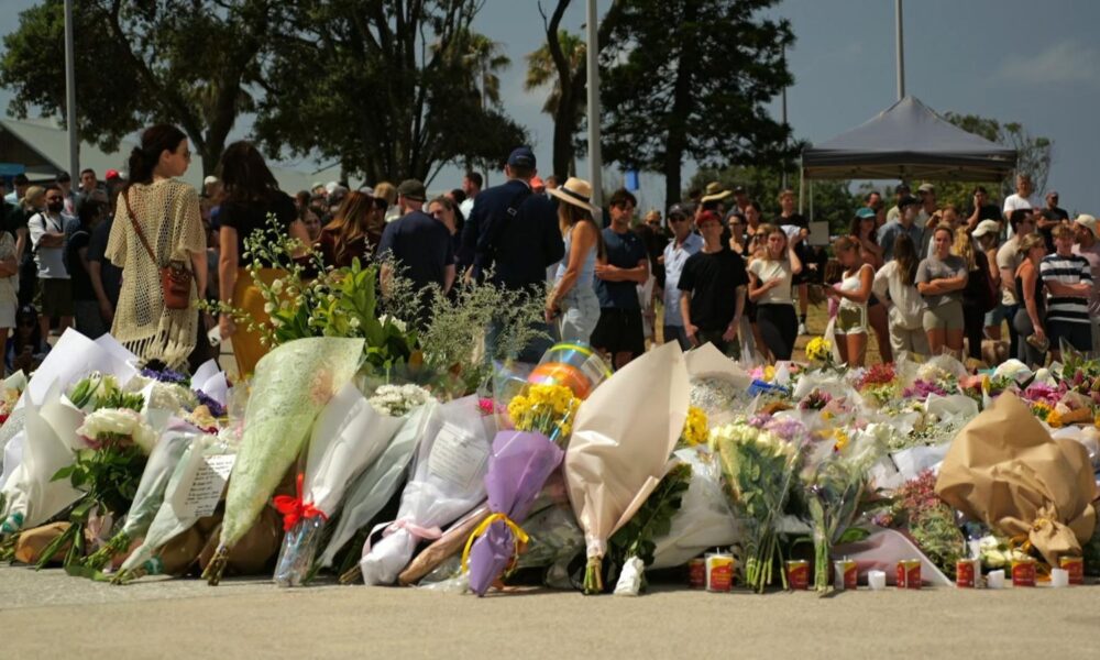 People leave flowers near the scene of the attack at Bondi Beach