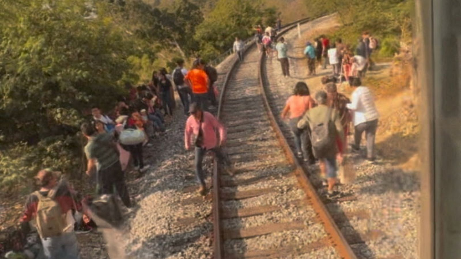 Passengers gather by tracks after a train derailment in Oaxaca state, Mexico. Pic: Social media video via Reuters