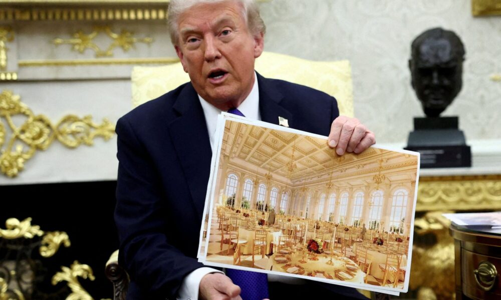 Donald Trump holds an image of the new White House ballroom. Pic: Reuters