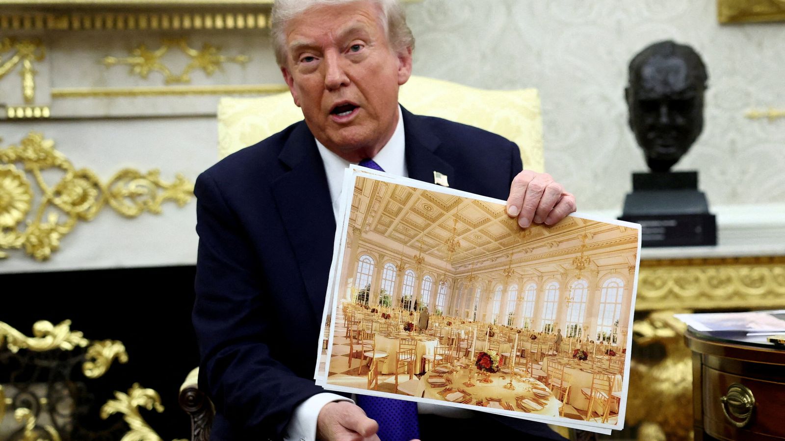 Donald Trump holds an image of the new White House ballroom. Pic: Reuters