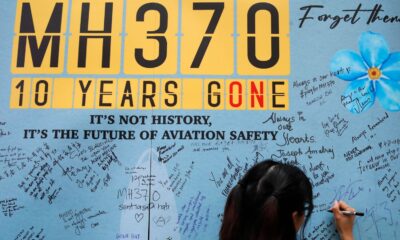 A woman writes a message on a board during last year's 10th annual remembrance event for missing flight MH370. Pic: AP