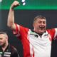 Mensur Suljovic celebrates defeating England's Joe Cullen at the World Darts Championship