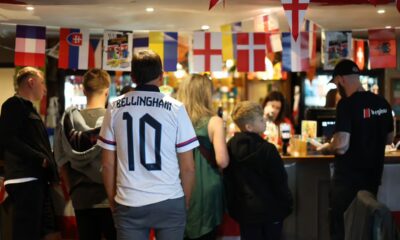 NEWCASTLE-UNDER-LYME, ENGLAND- JULY 14: A fan of England, wearing a shirt which reads "Bellingham 10", waits at a bar as England face Spain in the men's UEFA Euro 2024 final on July 14, 2024 in The Thistleberry pub in Newcastle-under-lyme, England. The match was held at the Olympiastadion in Berlin. (Photo by Carl Recine/Getty Images Europe)