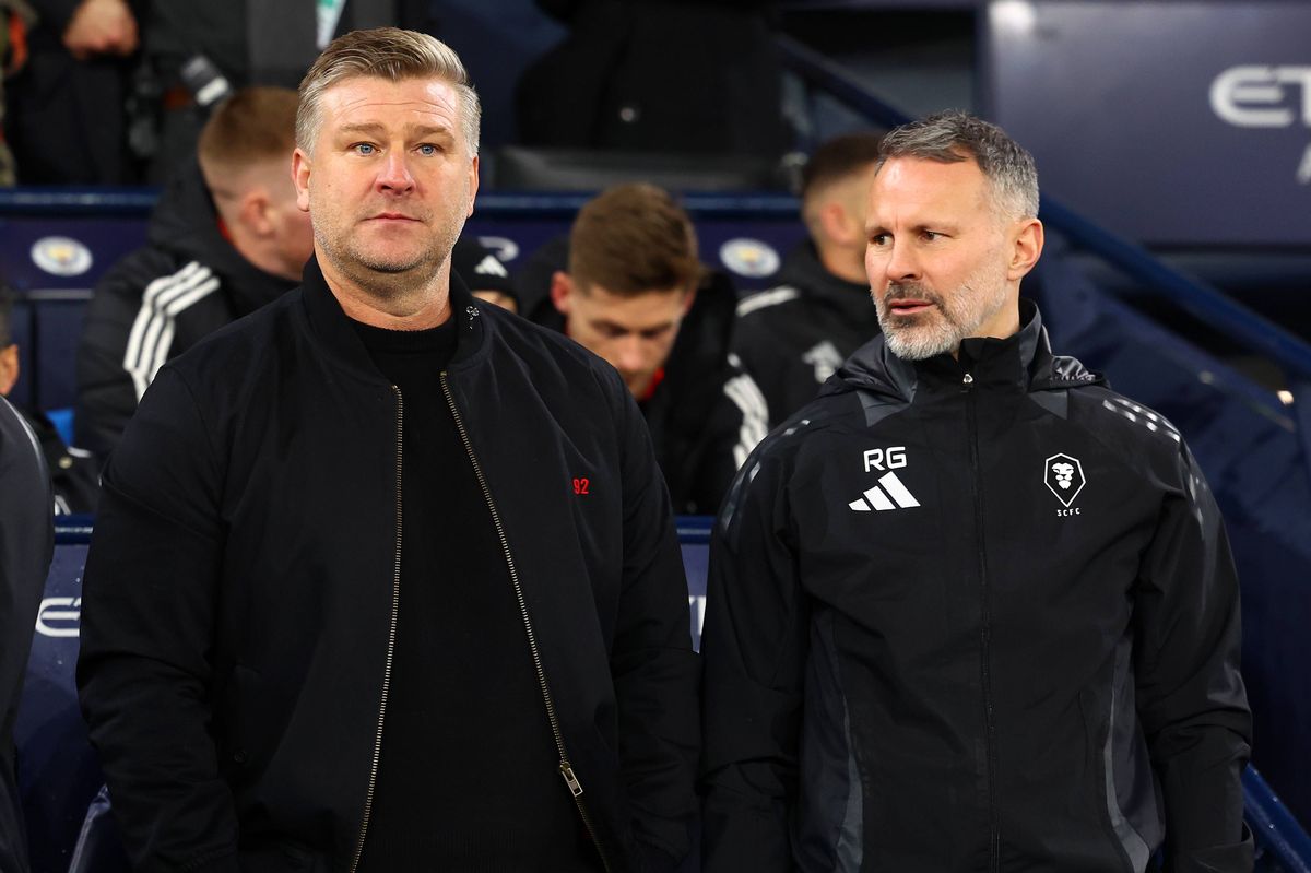 Salford City manager Karl Robinson (L) looks on next to assistant manager Ryan Giggs during the Emirates FA Cup Third Round match between Manchester City and Salford City at Etihad Stadium on January 11, 2025 in Manchester, England