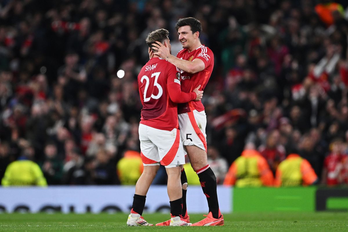 Luke Shaw and Harry Maguire celebrate victory after the UEFA Europa League 2024/25 Quarter Final Second Leg match between Manchester United and Olympique Lyonnais at Old Trafford.