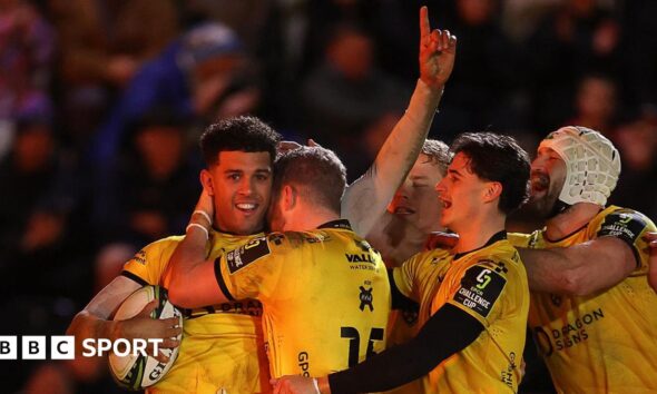 Rio Dyer celebrates with his Dragons teammates after scoring against Newcastle