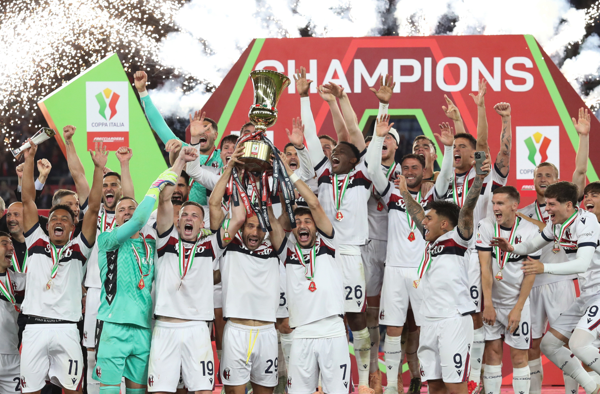 ROME, ITALY - MAY 14: Lewis Ferguson, Lorenzo De Silvestri and Riccardo Orsolini of Bologna lift the Coppa Italia trophy as their team mates celebrate after the team's victory in the Coppa Italia Final match between AC Milan and Bologna at Stadio Olimpico on May 14, 2025 in Rome, Italy. (Photo by Paolo Bruno/Getty Images)