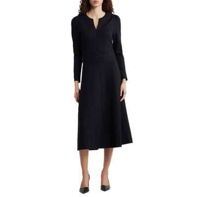 A woman wearing a black midi dress and black slingbacks