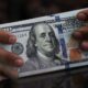 Dollar poised for third weekly gain as buoyant data seen keeping Fed cuts at bay