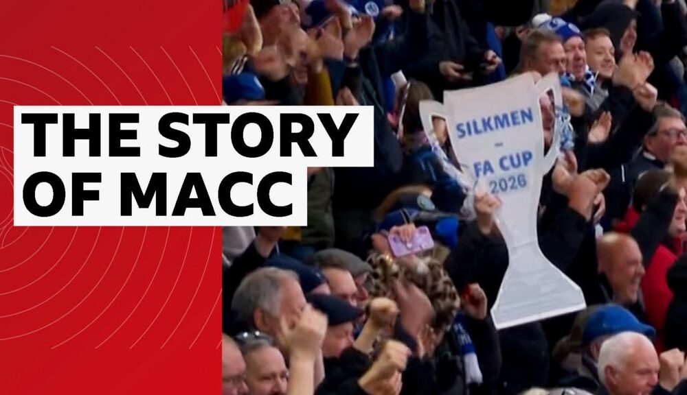 Macclesfield FC fans holding a cardboard cut-out FA Cup