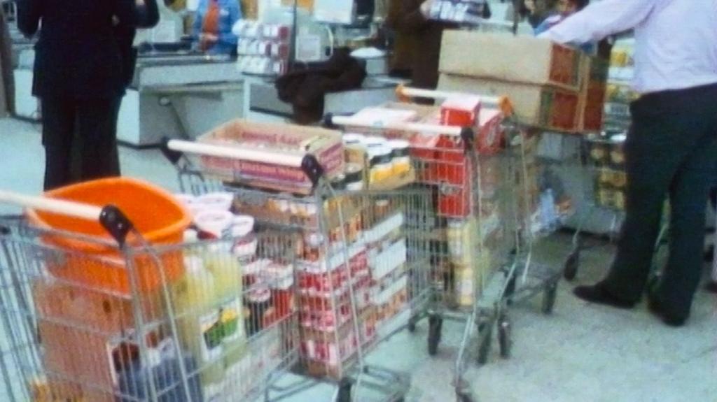 A line of supermarket trolleys piled high with bulk buy amounts of groceries.