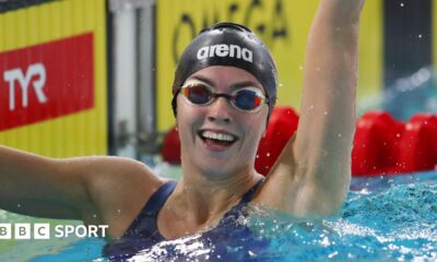 Swimmer Emily Barclay smiles and waves after a race
